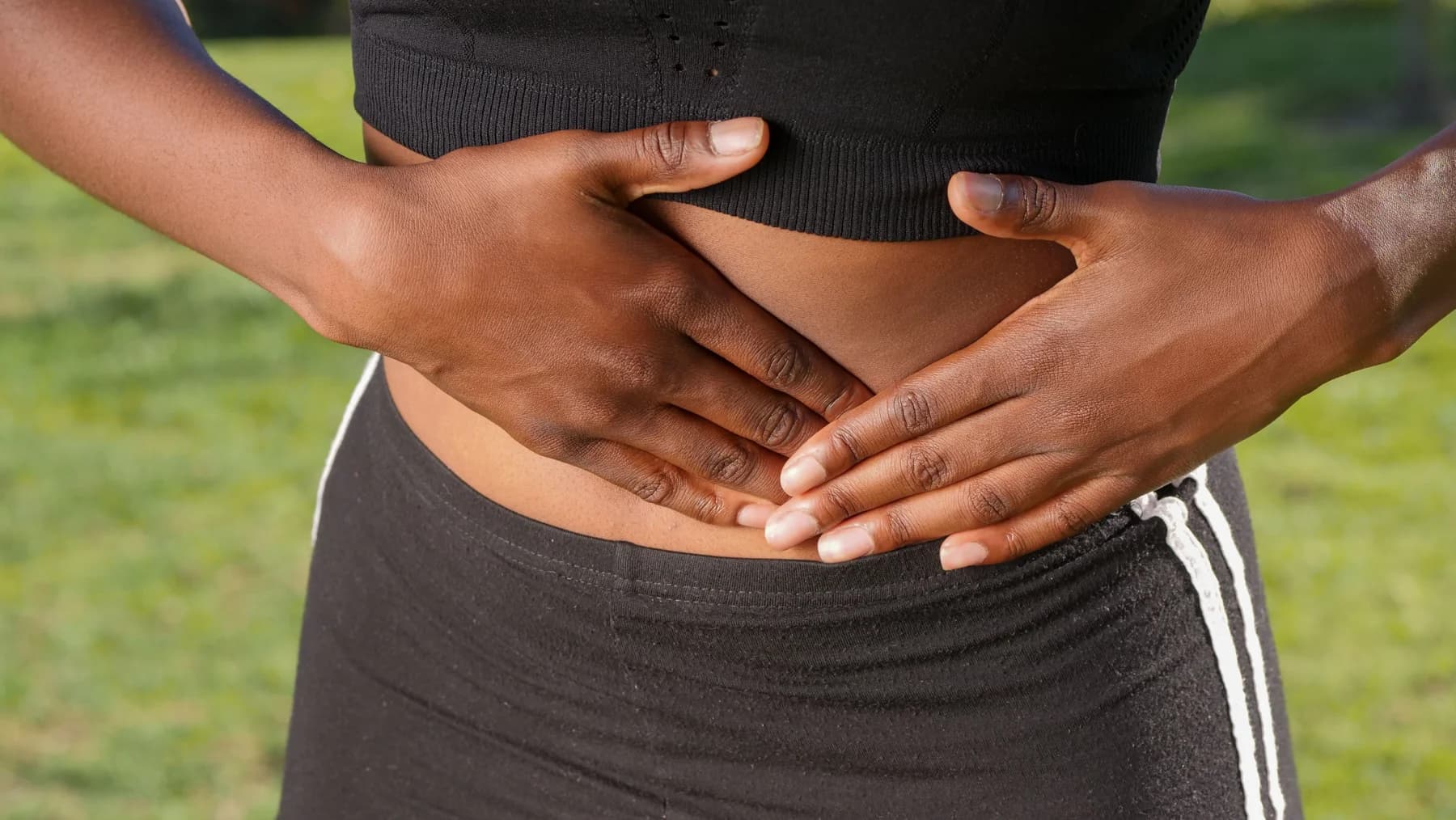 A person holding their lower abdomen