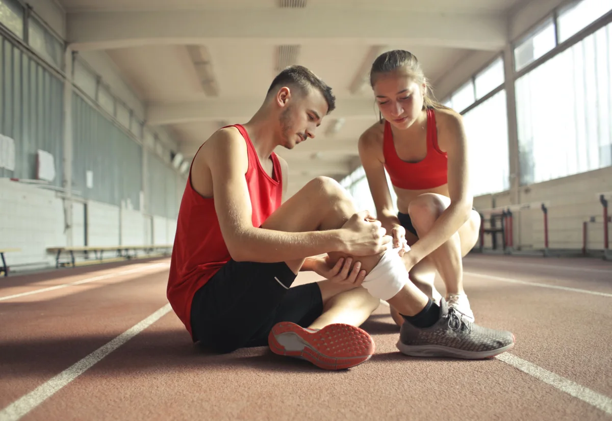 An athlete receiving support for a knee injury