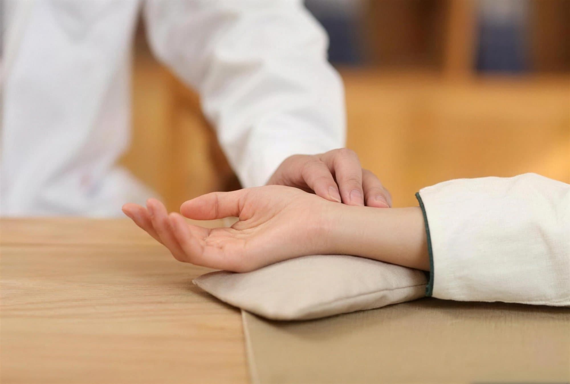 Practitioner reading a patient's pulse at the wrist
